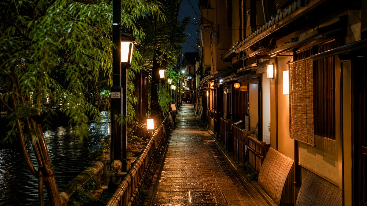 Pontocho alley in Kyoto at night beside the river with warm restaurant lights